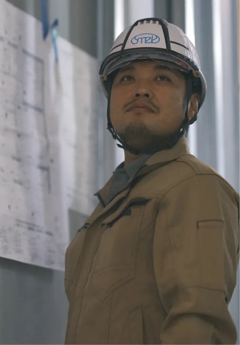 ヘルメットを着用した作業員が前方を見上げている様子