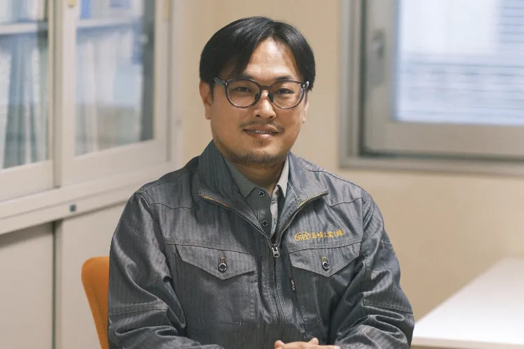  メガネをかけた男性がデニムジャケットを着用している様子