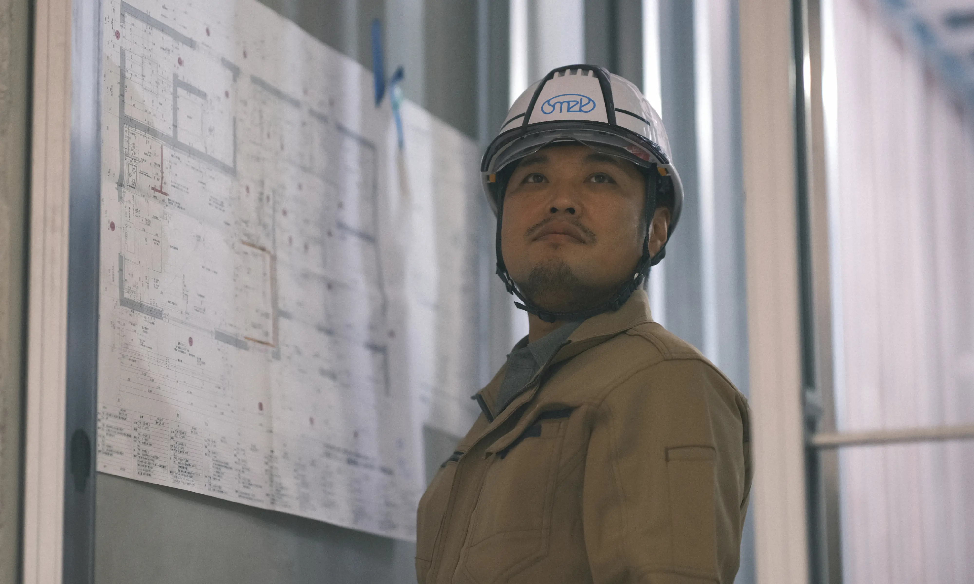 ヘルメットを着用した作業員が前方を見上げている様子