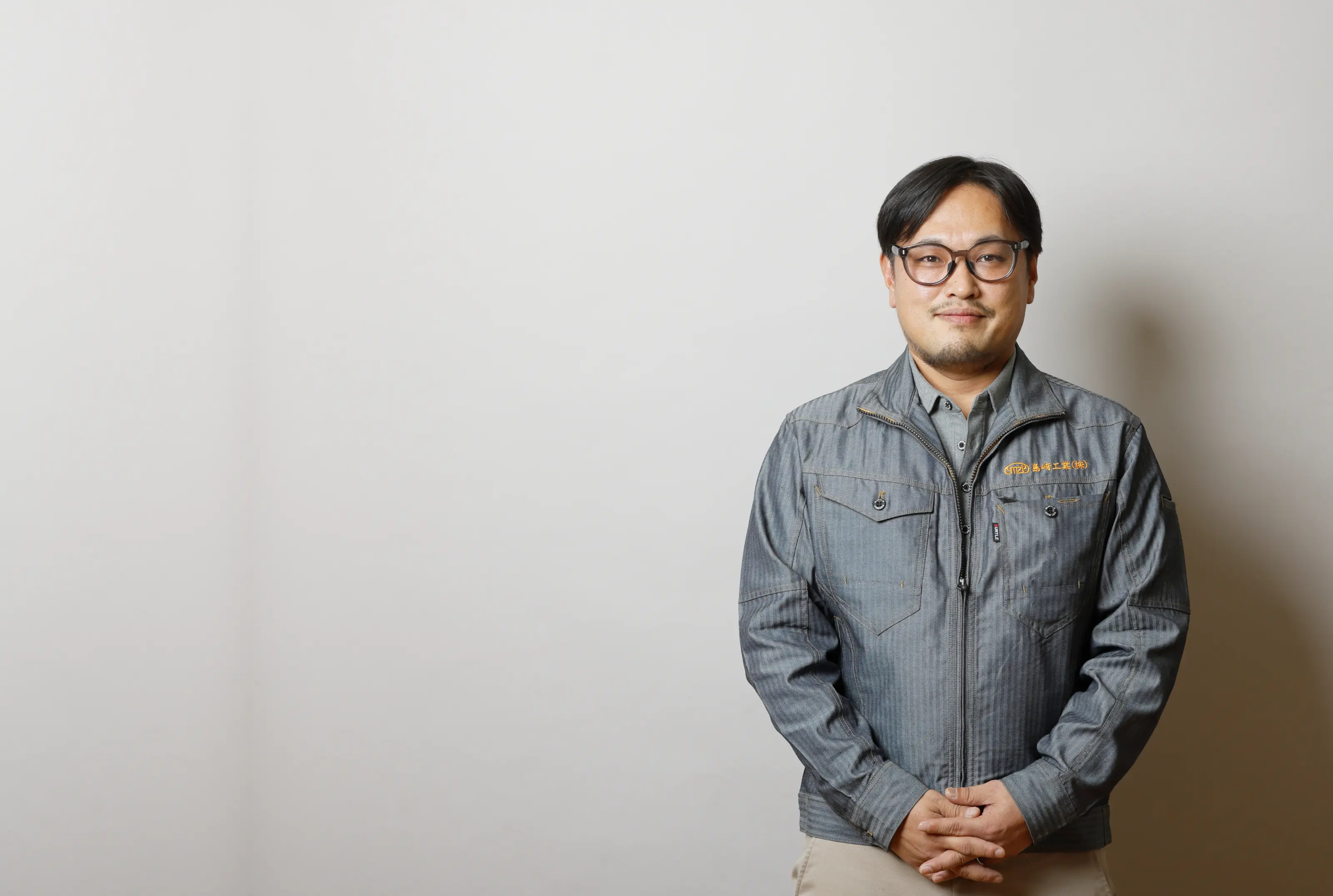 作業服を着用し、信頼感のある微笑みを浮かべる技術者のポートレート