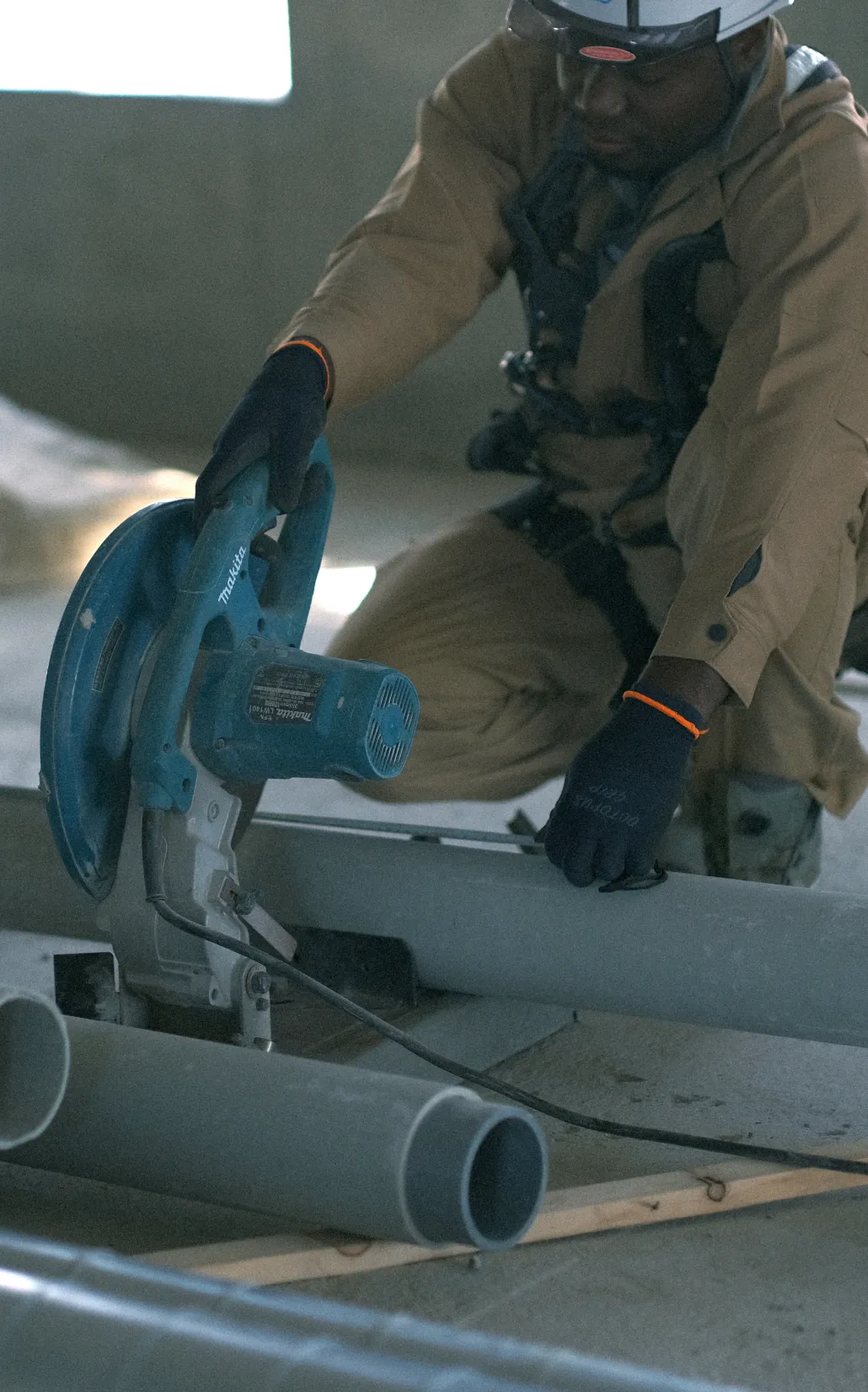 図面を真剣な表情で確認するヘルメット姿の男性スタッフ二人